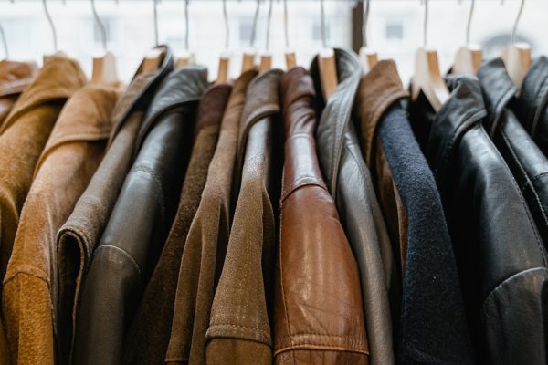 A close-up view of leather jackets hanging neatly on a rack inside a store.